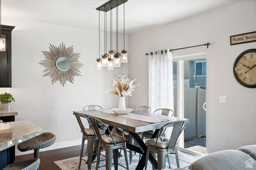 Dining space with baseboards and dark wood-type flooring