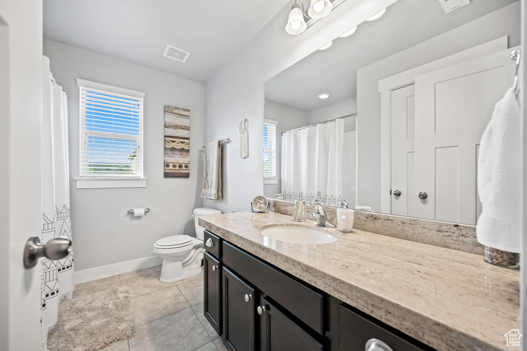 Full bath with baseboards, toilet, visible vents, tile patterned flooring, and vanity