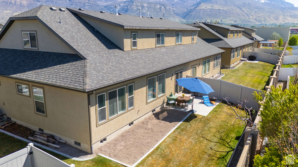 Back of house with a mountain view, a patio, stucco siding, crawl space, and a shingled roof