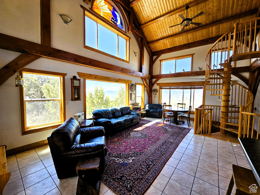 Living room featuring light tile patterned flooring, plenty of natural light, and beam ceiling
