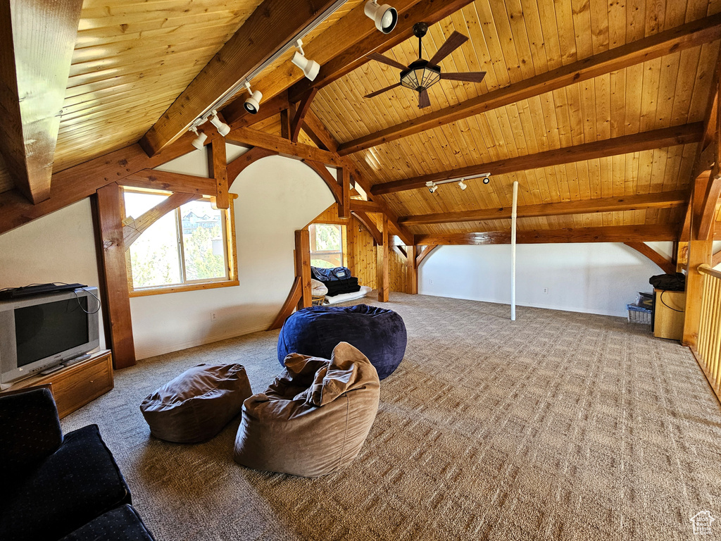 Additional living space with wooden ceiling, ceiling fan, carpet flooring, and lofted ceiling with beams
