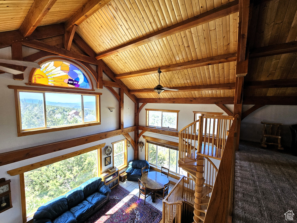 Living area with wood ceiling, a ceiling fan, and vaulted ceiling with beams