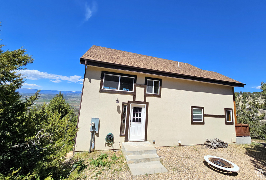 View of front of house with stucco siding and a fire pit
