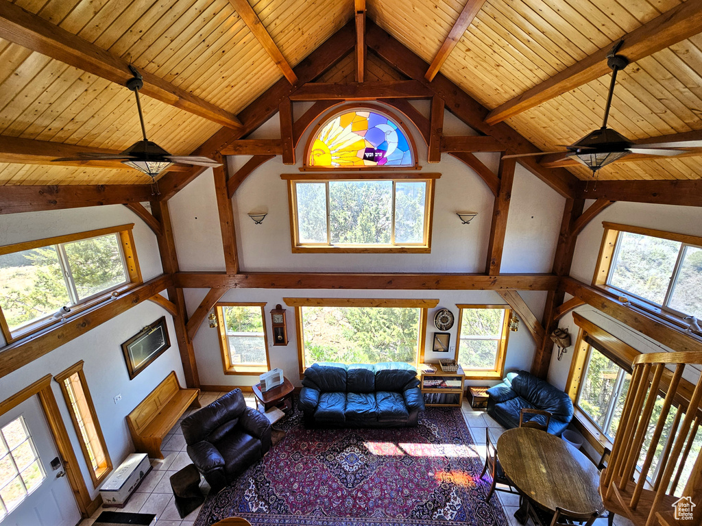 Living area featuring a healthy amount of sunlight, high vaulted ceiling, and a ceiling fan
