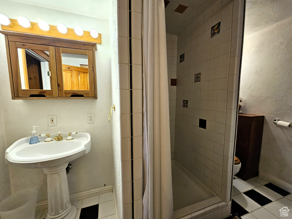 Full bathroom featuring baseboards, a shower stall, and tile patterned flooring