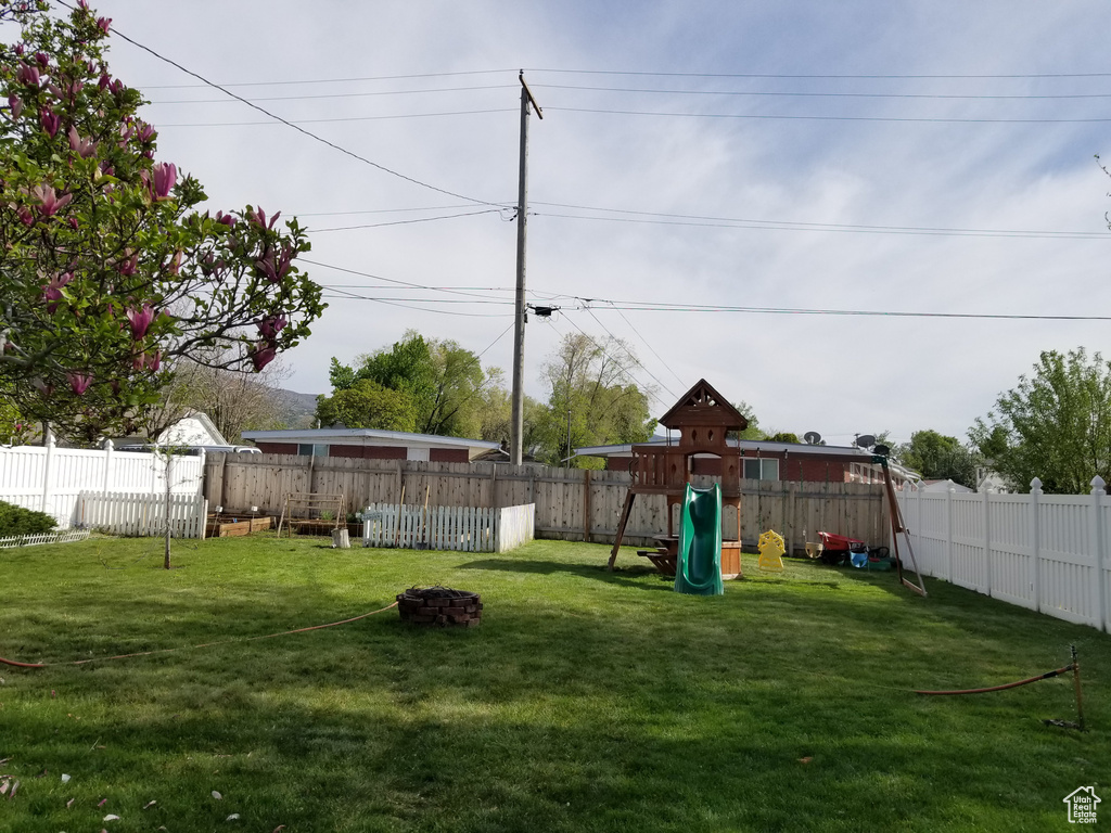 View of yard featuring a fenced backyard and a playground