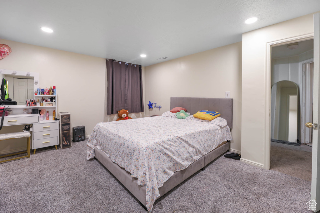 Carpeted bedroom with recessed lighting and arched walkways