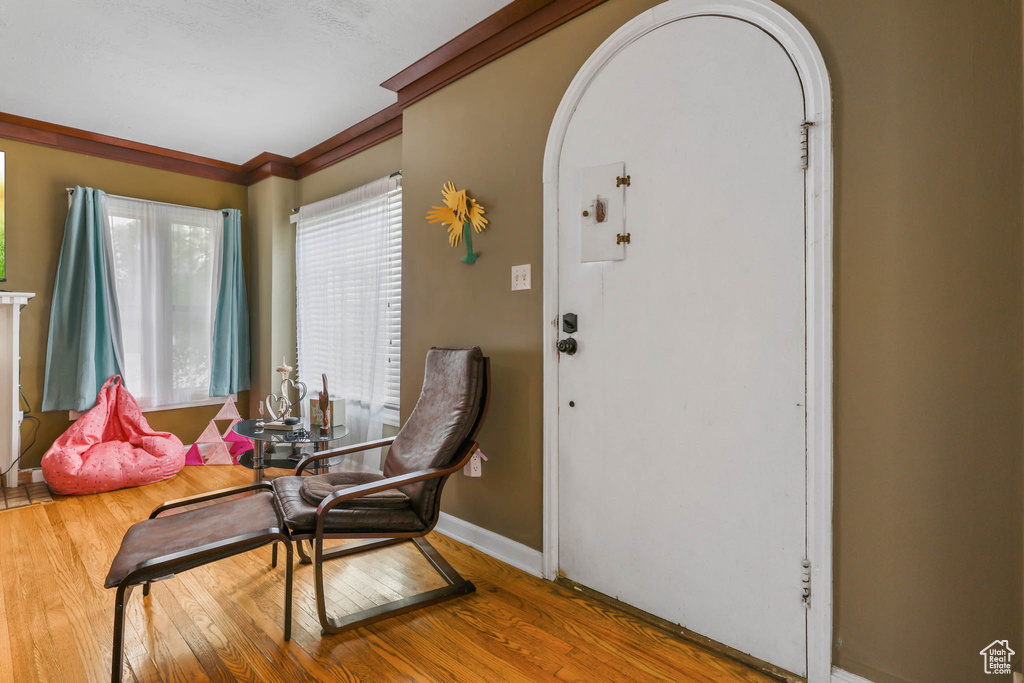 Entrance foyer featuring arched walkways, wood finished floors, and baseboards
