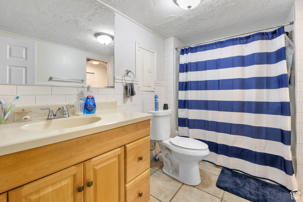 Bathroom with tile patterned flooring, vanity, a textured ceiling, toilet, and a shower with curtain