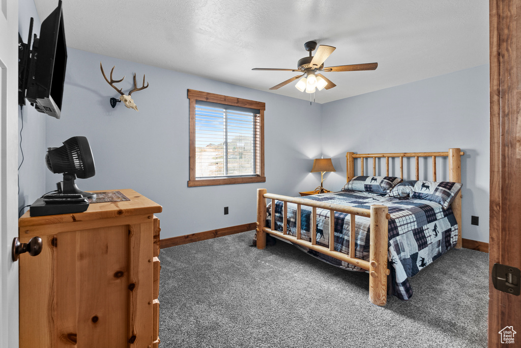 Carpeted bedroom with baseboards and a ceiling fan