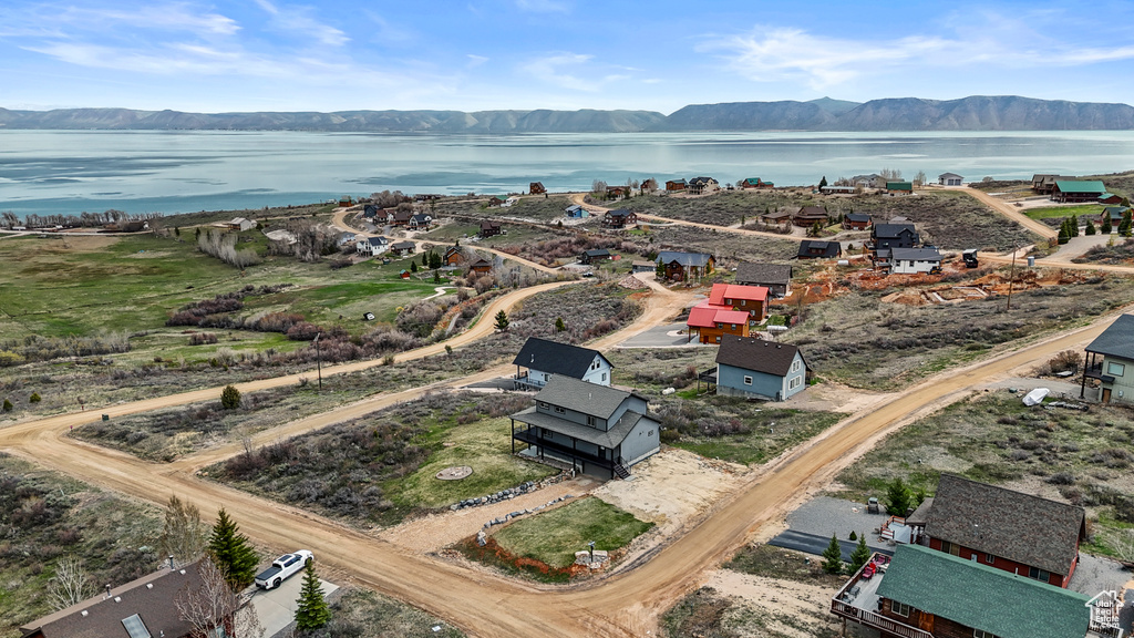 Birds eye view of property with a water and mountain view