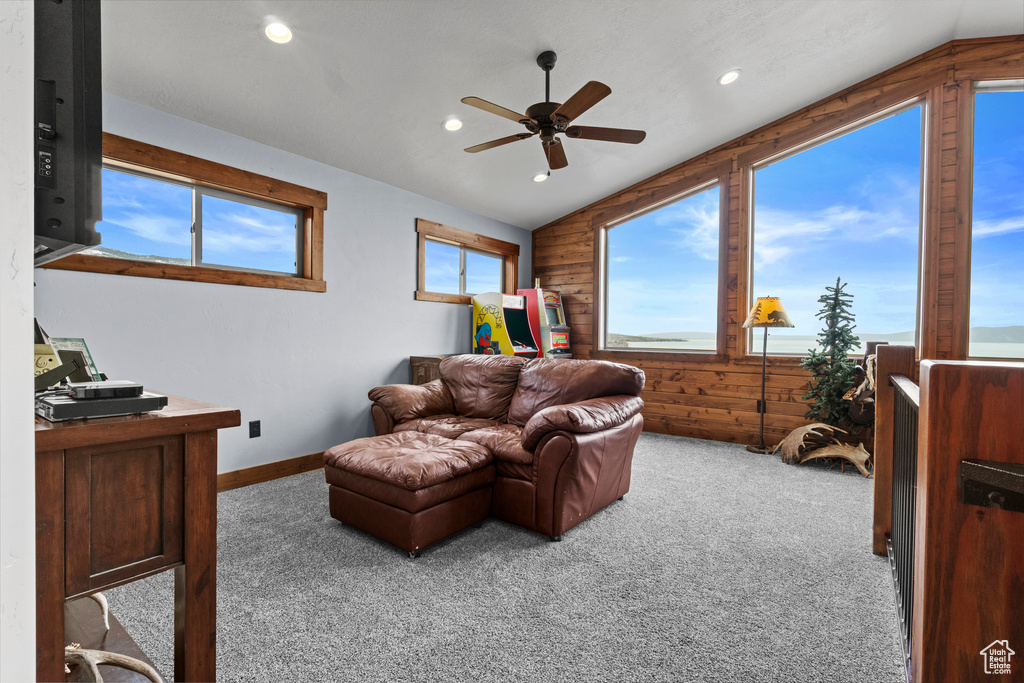 Living room featuring a ceiling fan, recessed lighting, carpet, wooden walls, and vaulted ceiling