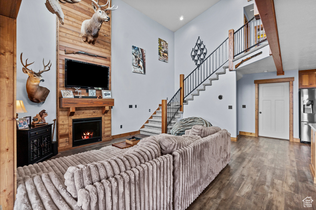 Living area featuring recessed lighting, baseboards, stairs, wood finished floors, and a large fireplace