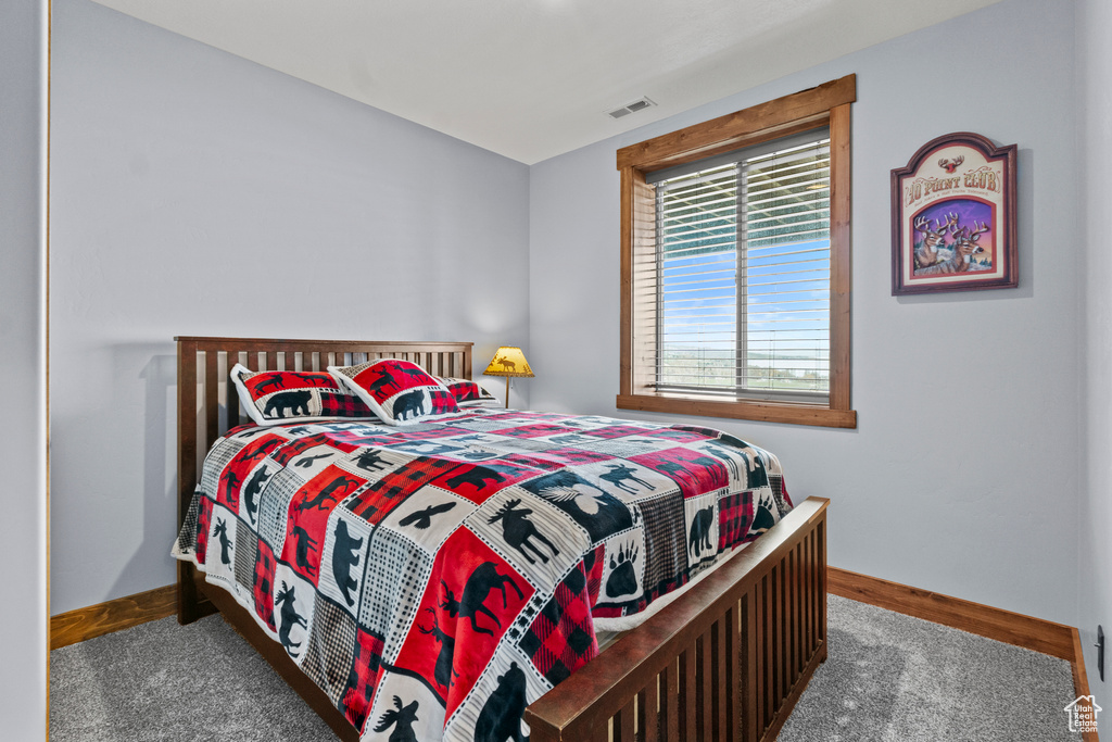 Carpeted bedroom with baseboards and visible vents