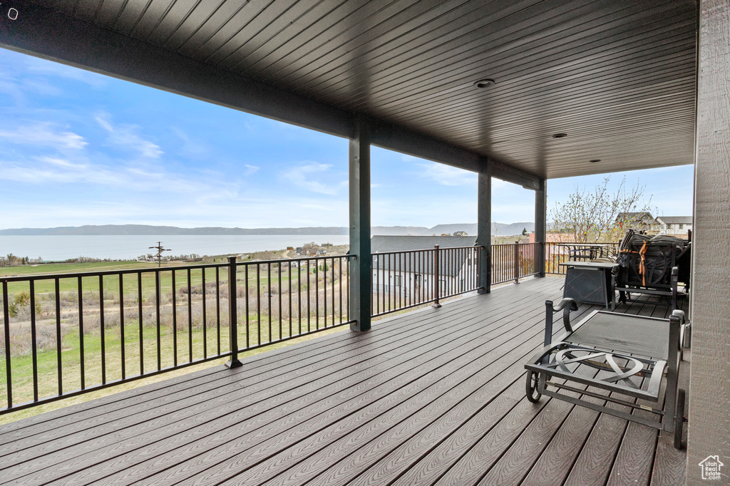 Wooden terrace featuring a water and mountain view