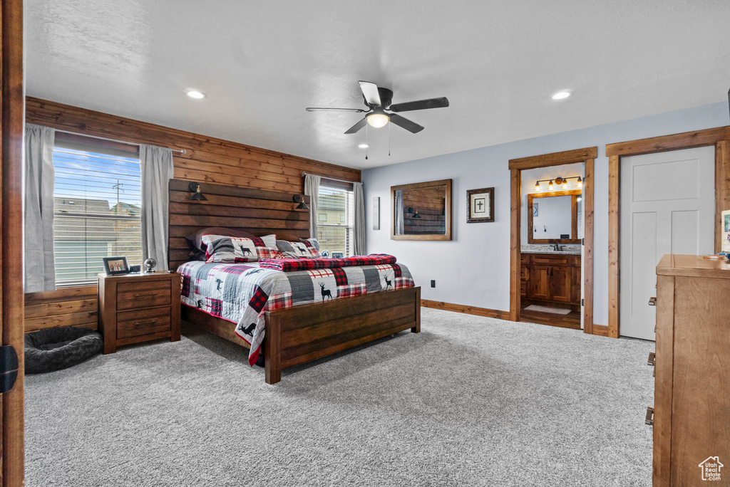 Carpeted bedroom with wooden walls, baseboards, and recessed lighting