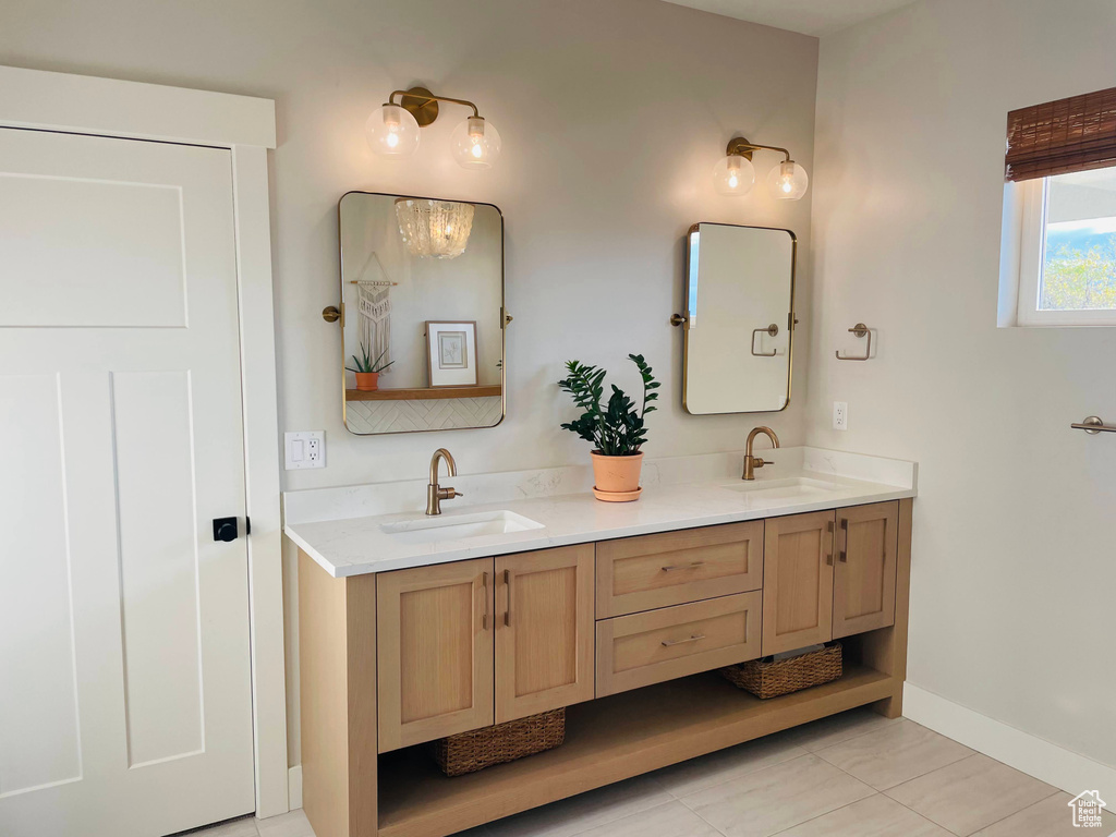 Full bathroom with a sink, baseboards, tile patterned floors, and double vanity