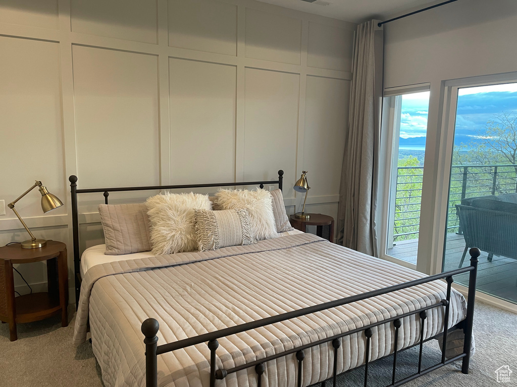 Bedroom featuring carpet flooring and a decorative wall