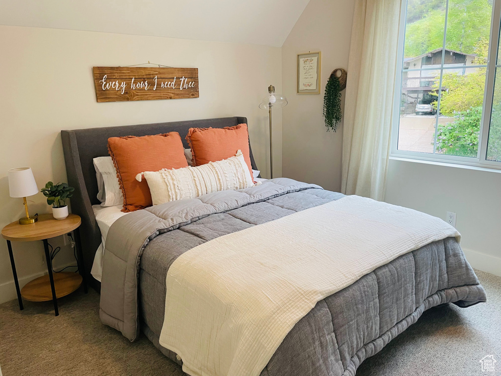 Bedroom featuring carpet flooring, baseboards, and lofted ceiling