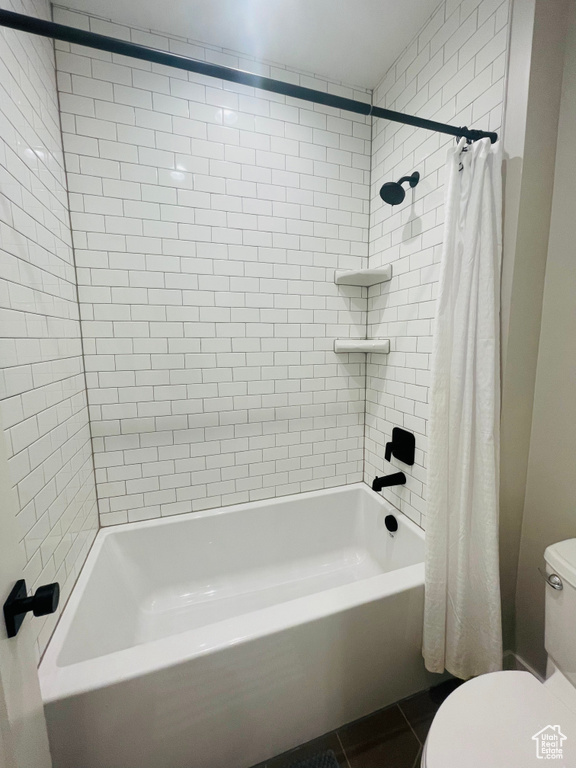 Bathroom with shower / tub combo, tile patterned floors, and toilet