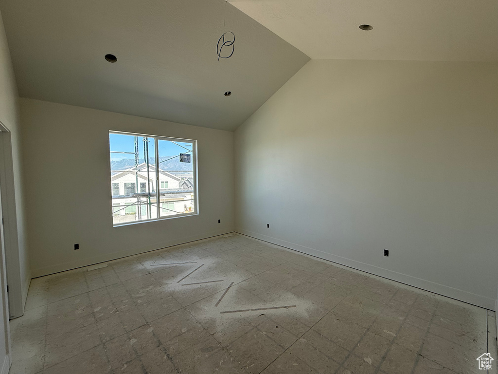 Empty room with vaulted ceiling and recessed lighting