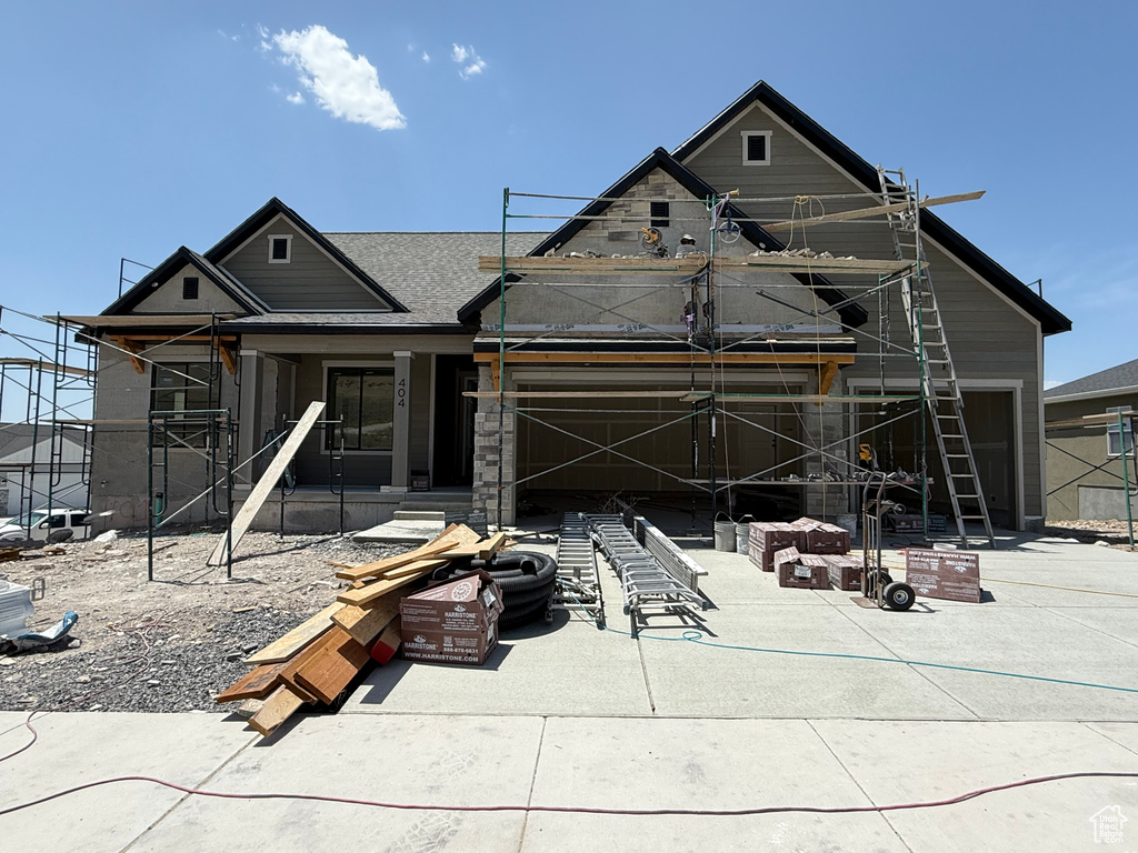 Rear view of property featuring covered porch and a garage
