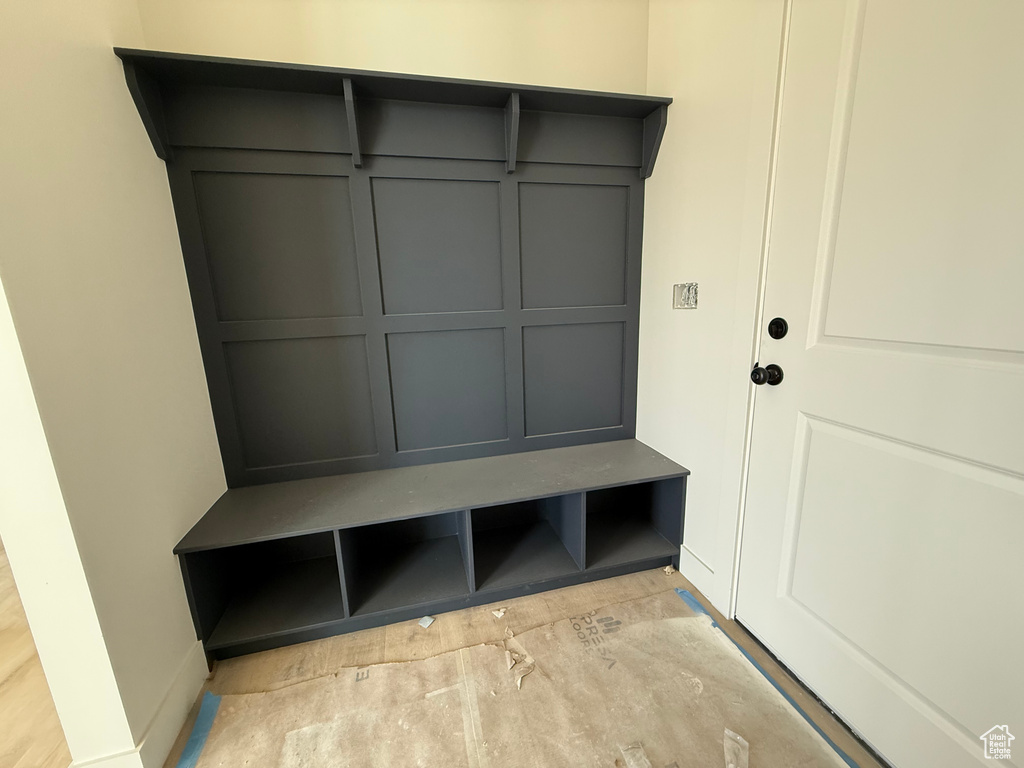 Mudroom featuring concrete floors and a decorative wall