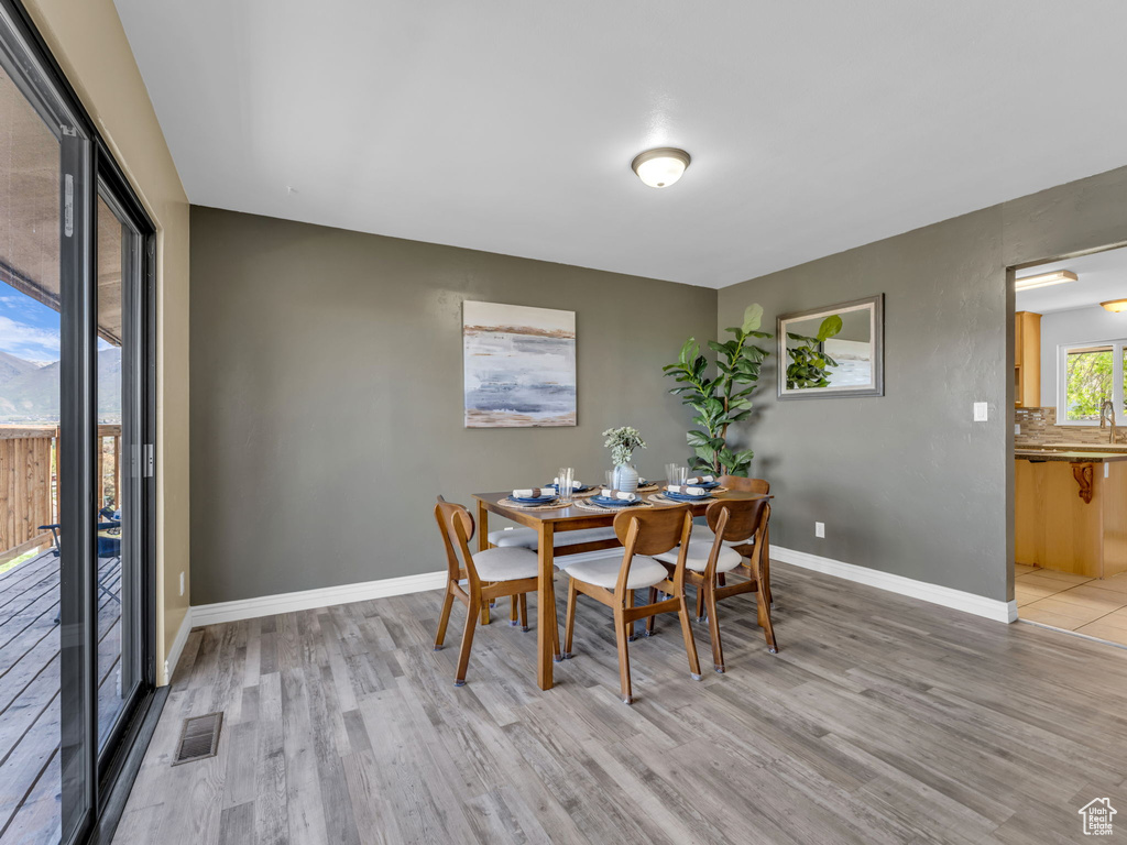 Dining room with baseboards, light wood-style floors, and visible vents