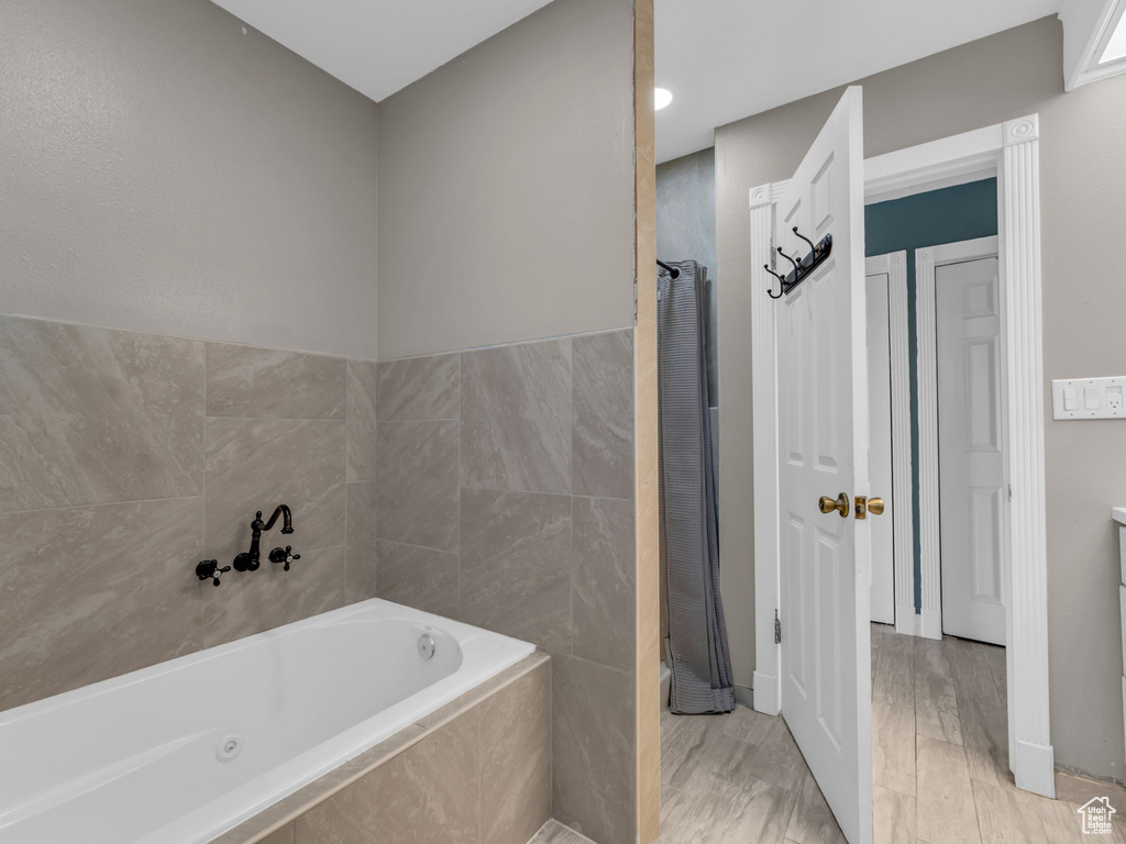 Full bathroom with a garden tub and wood finished floors