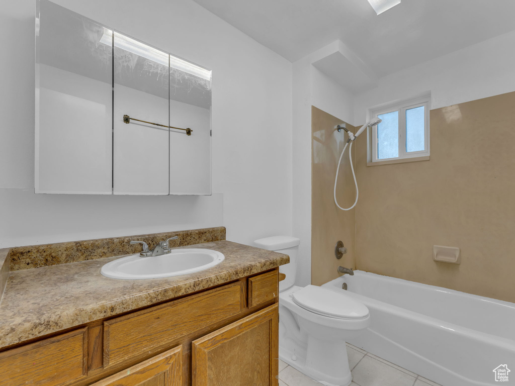 Bathroom featuring tile patterned flooring, toilet, shower / tub combination, and vanity