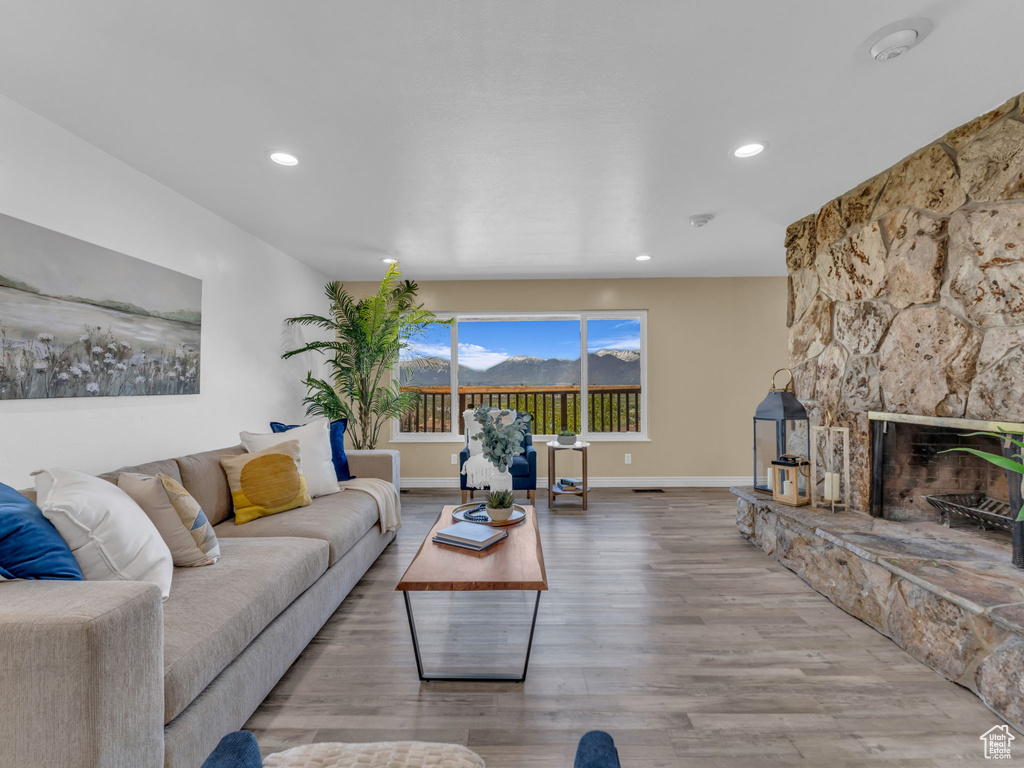 Living area with baseboards, a fireplace, recessed lighting, and wood finished floors