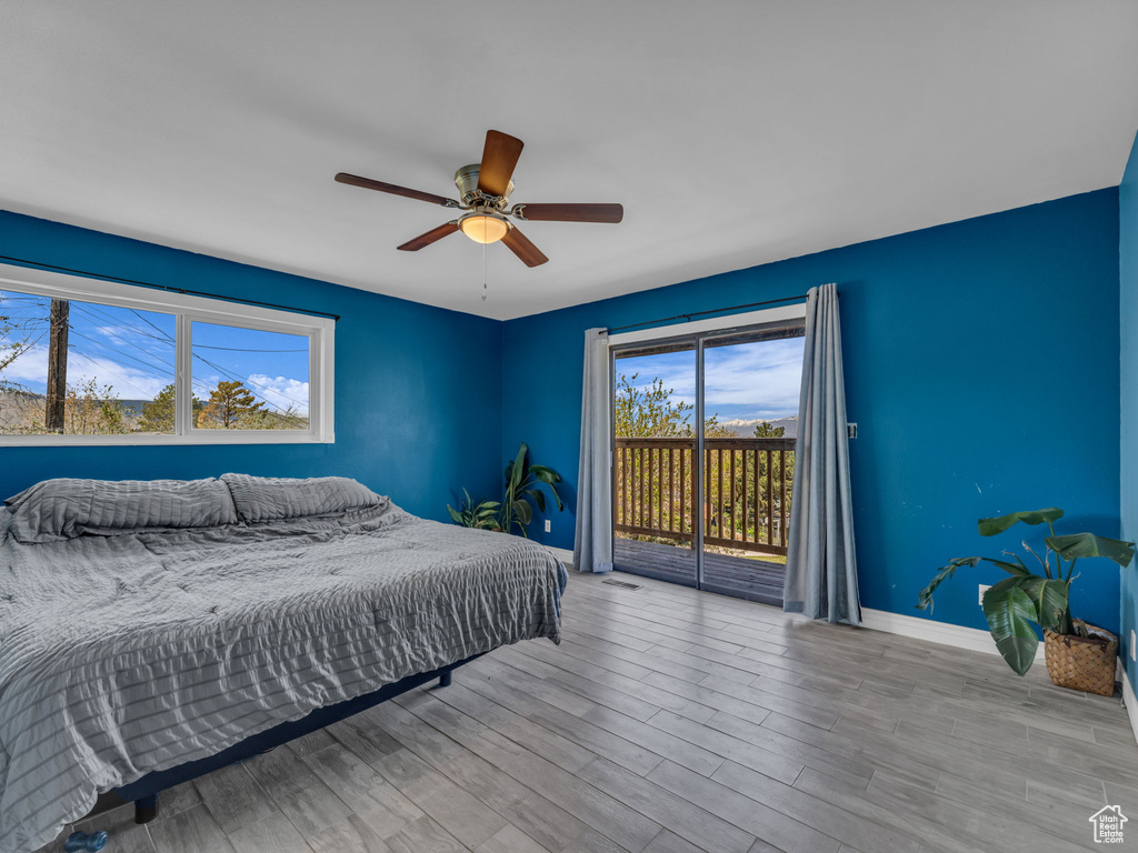 Bedroom featuring a ceiling fan, baseboards, visible vents, access to outside, and wood finished floors