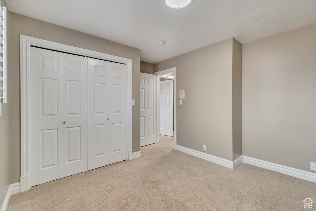 Unfurnished bedroom with baseboards, a closet, and carpet