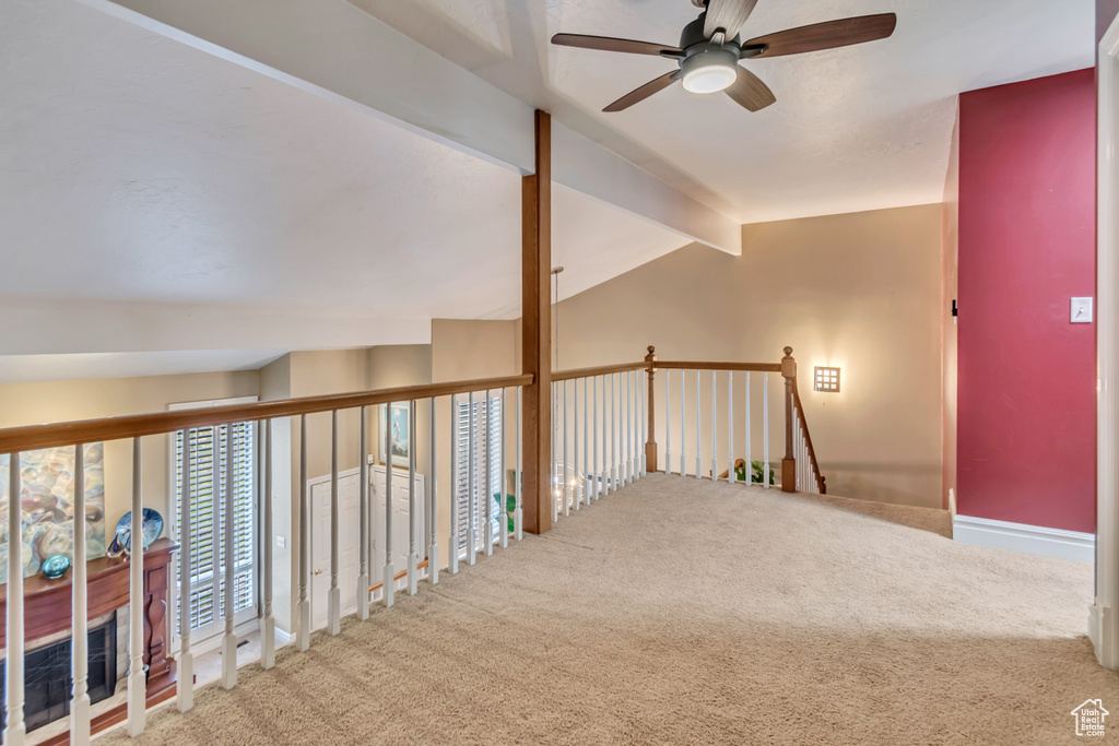 Corridor with lofted ceiling with beams and carpet floors