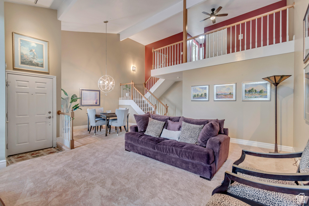 Living area featuring high vaulted ceiling, beam ceiling, carpet floors, stairway, and baseboards