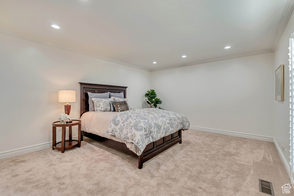 Bedroom featuring crown molding, light carpet, baseboards, and visible vents