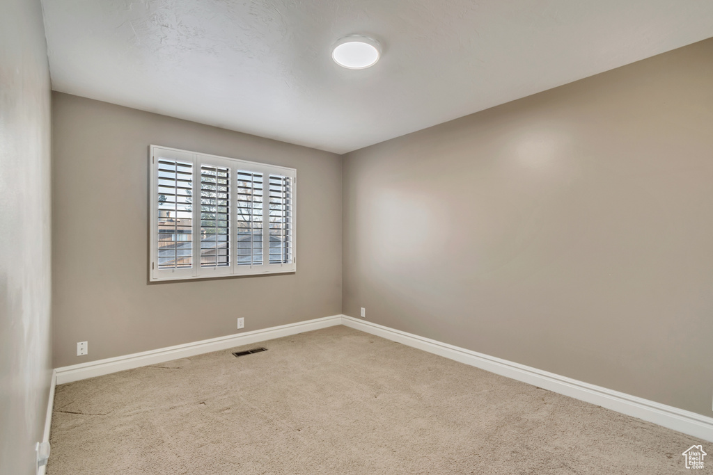 Unfurnished room featuring visible vents, baseboards, and carpet floors