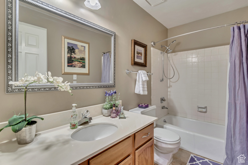 Bathroom with toilet, tile patterned flooring, vanity, and shower / bath combo with shower curtain