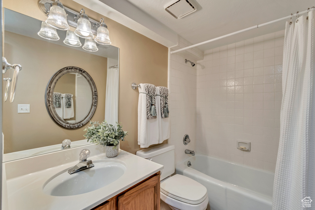 Full bathroom with vanity, toilet, visible vents, and shower / bath combo