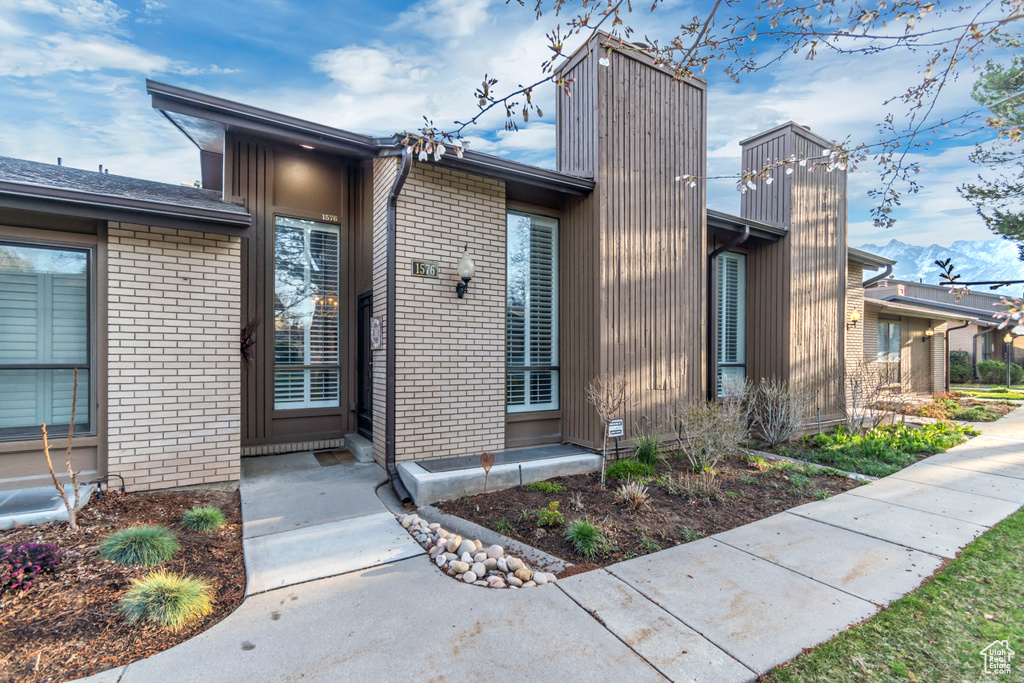 Exterior space featuring a mountain view, a chimney, and brick siding