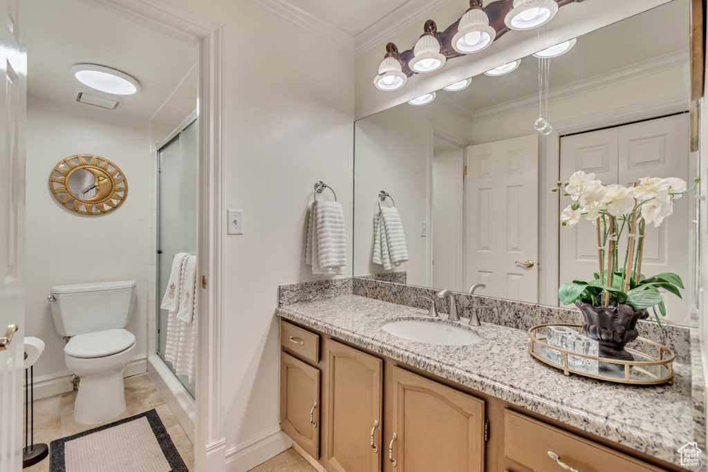 Bathroom with toilet, baseboards, a shower stall, and vanity