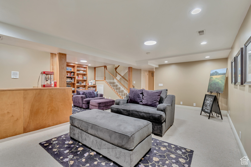 Living room with stairs, visible vents, recessed lighting, carpet floors, and baseboards