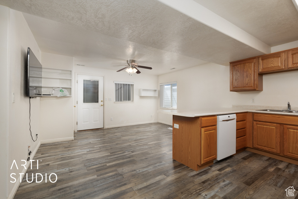Kitchen with a ceiling fan, white dishwasher, dark wood-style flooring, a sink, and a peninsula