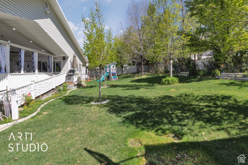 View of yard with a fenced backyard and playground community