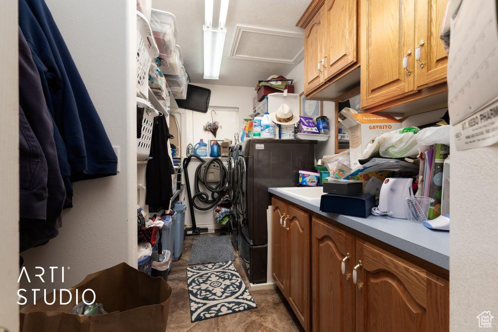 Laundry area featuring separate washer and dryer, attic access, and cabinet space