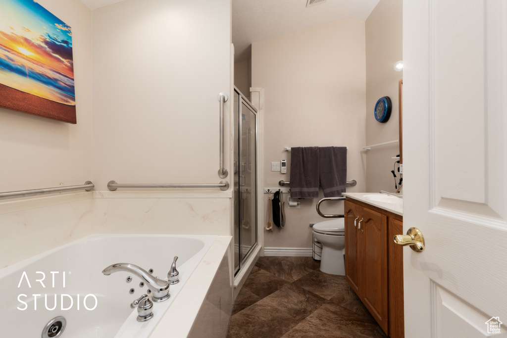 Bathroom featuring a shower stall, vanity, toilet, and a whirlpool tub