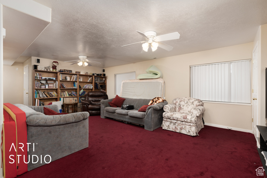 Living area with carpet flooring, a textured ceiling, and a ceiling fan