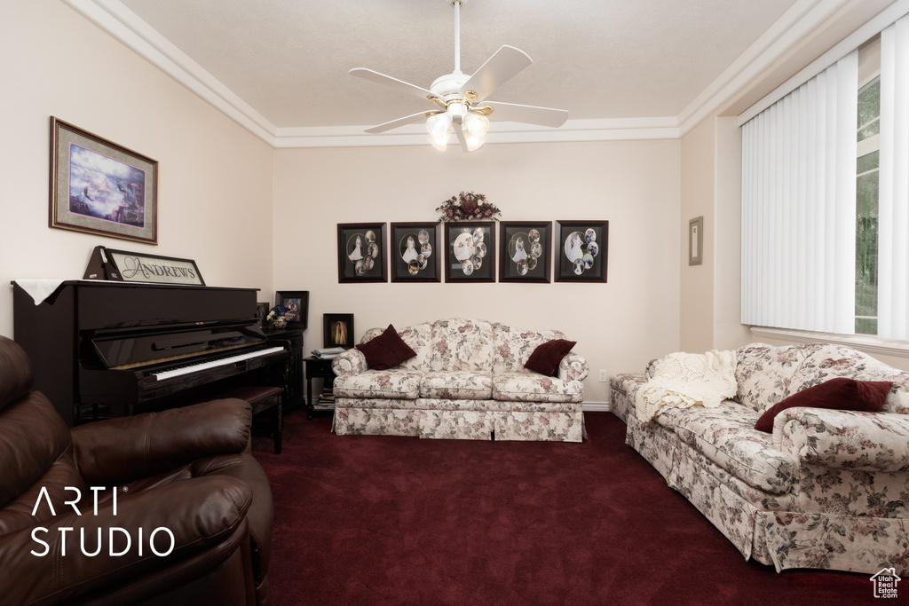 Living area with ceiling fan, ornamental molding, carpet flooring, and a healthy amount of sunlight