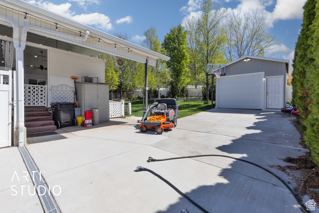 View of patio / terrace with an outdoor structure, a garage, and fence