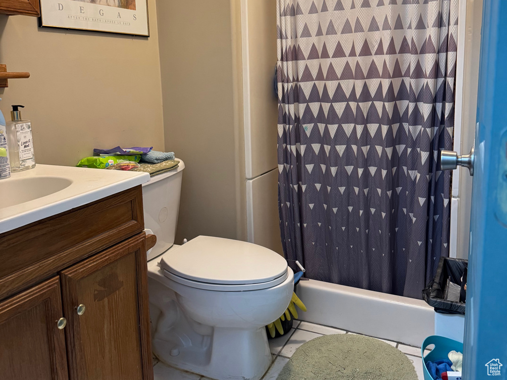 Bathroom with toilet, a shower with curtain, tile patterned floors, vanity, and ornamental molding